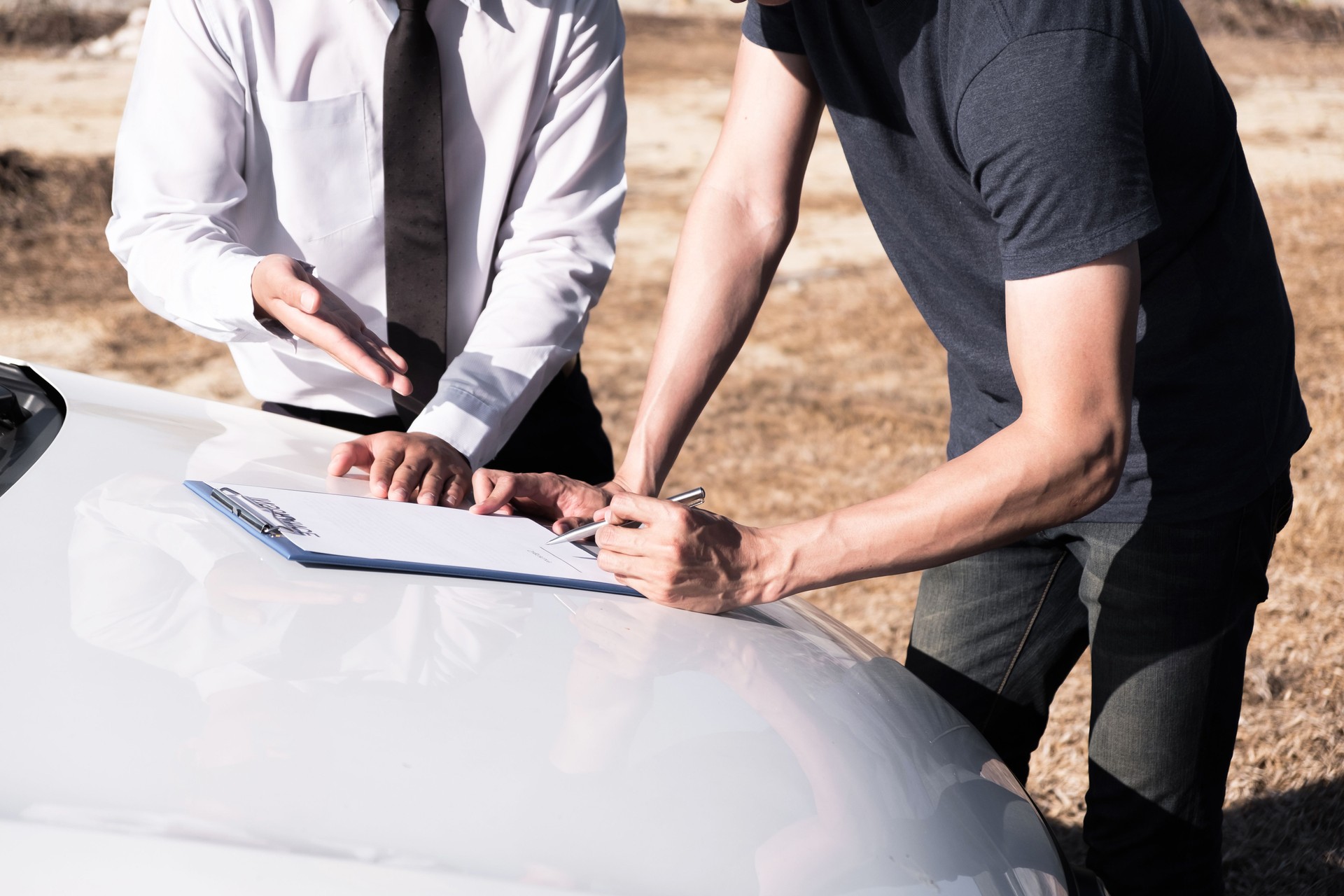Insurance agent giving the car owner is sign the agreement for accident claim.
